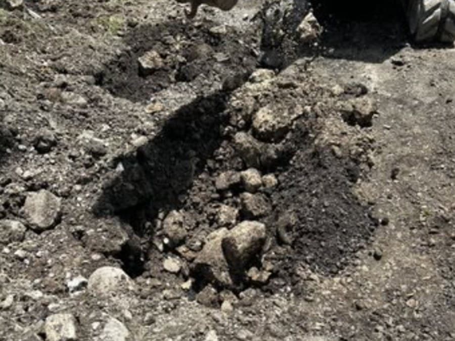 Excavator exposing large rounded boulders in obstructed made ground at the Halls of Justice site