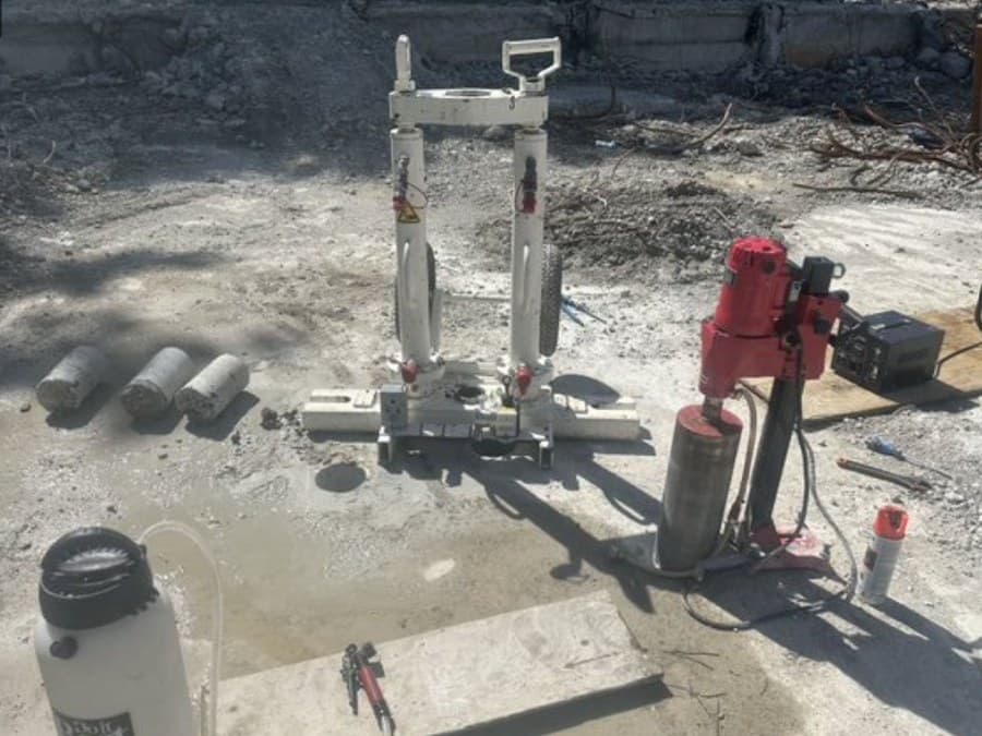 Concrete cores extracted from the existing reinforced concrete slab beside the coring rig
