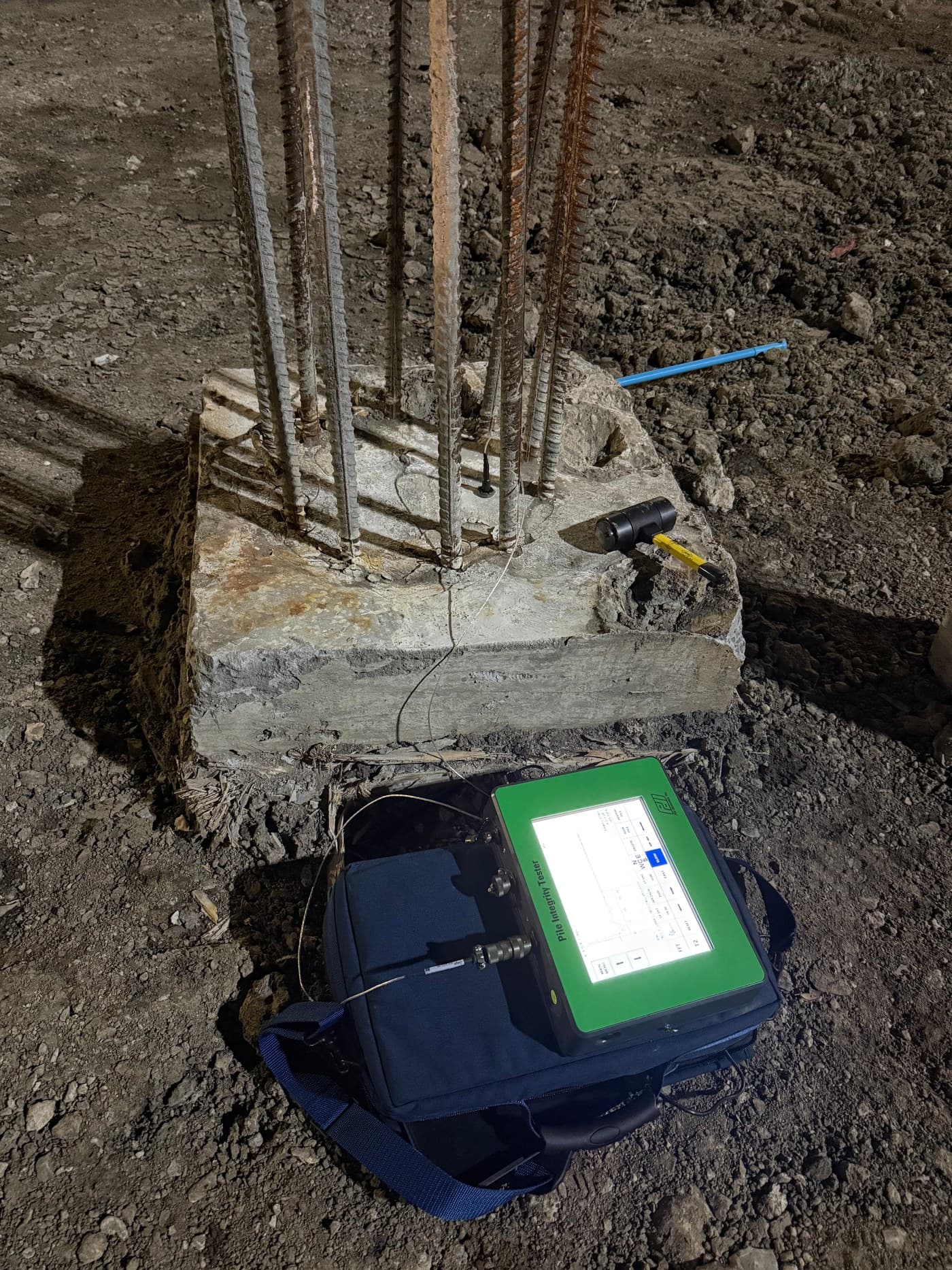 GID field technician collecting Pile Integrity Testing data at a pile head using a Pile Integrity Tester