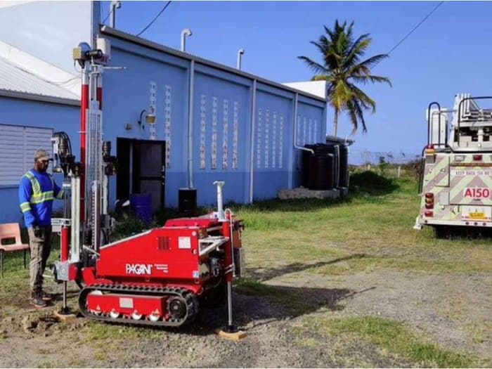 GID technician operating a CPTu rig beside an ARFF fire truck at Hewanorra International Airport